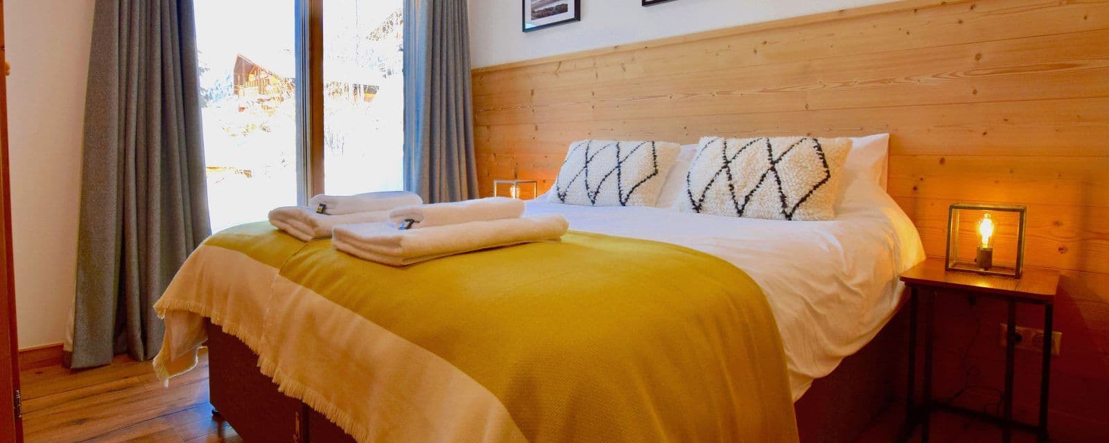 King/twin bedroom with a timber headboard and large window