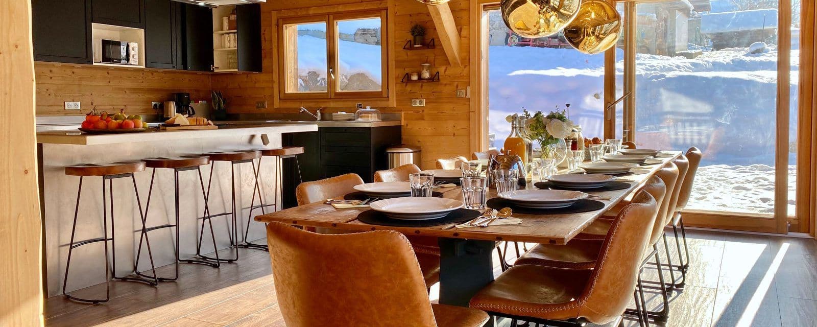 Open-plan kitchen and long dining table beside the snowy deck