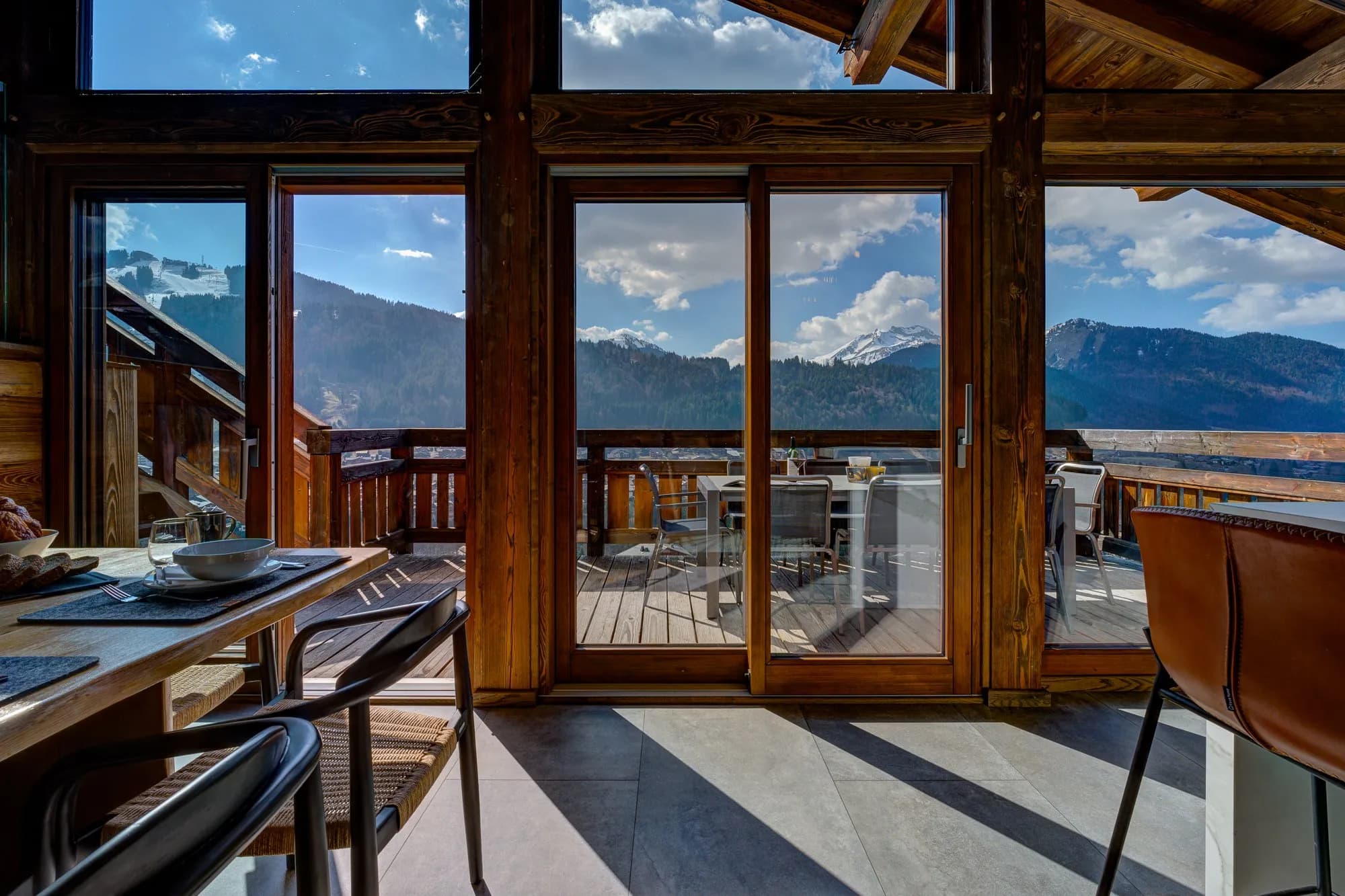 Dining area with floor-to-ceiling windows; snow-capped mountain views