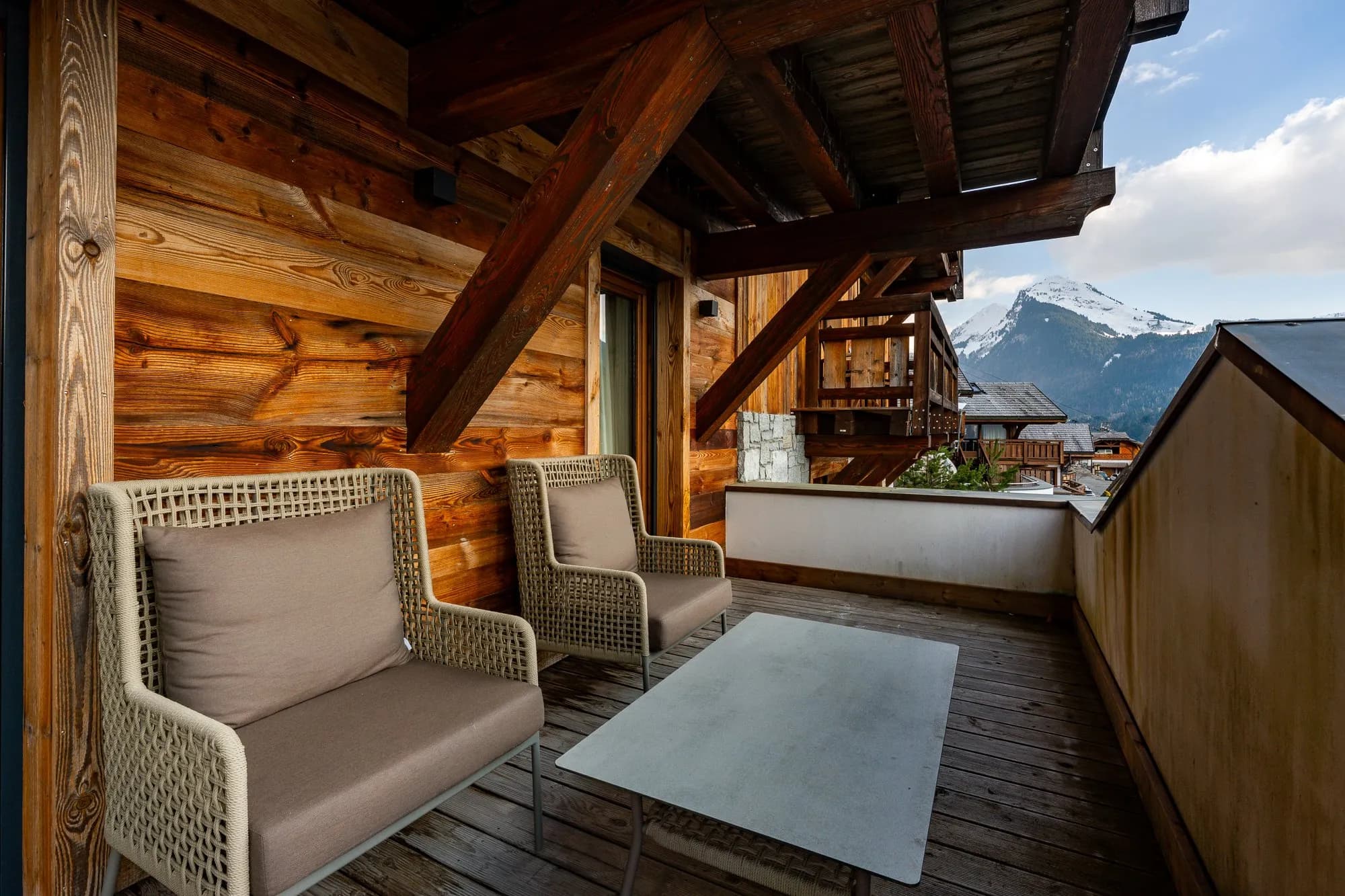 Private balcony with dual lounge chairs; snow-capped mountain views