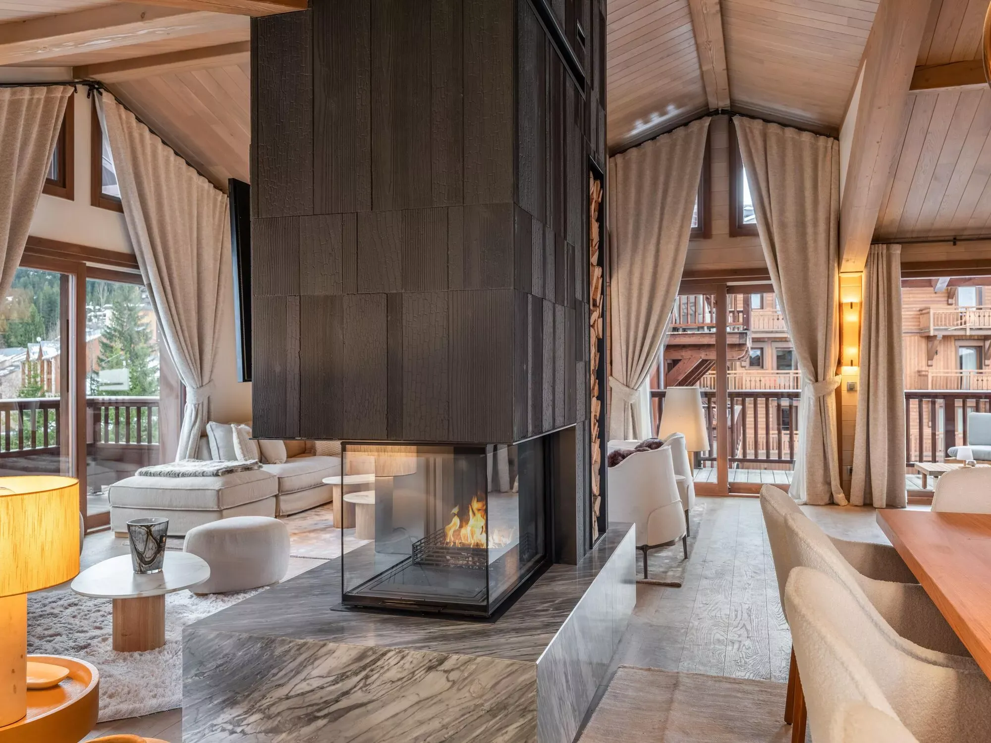 Double-sided wood fireplace between two lounge seating areas