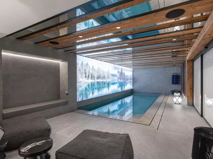 Indoor swimming pool with a glazed ceiling and lounge seating