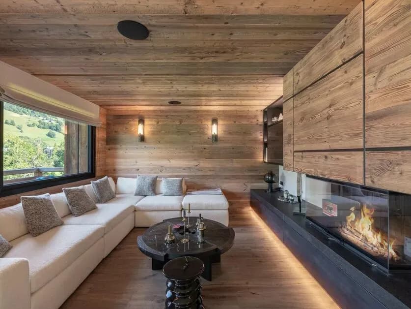 Television lounge with a central fireplace and timber walls