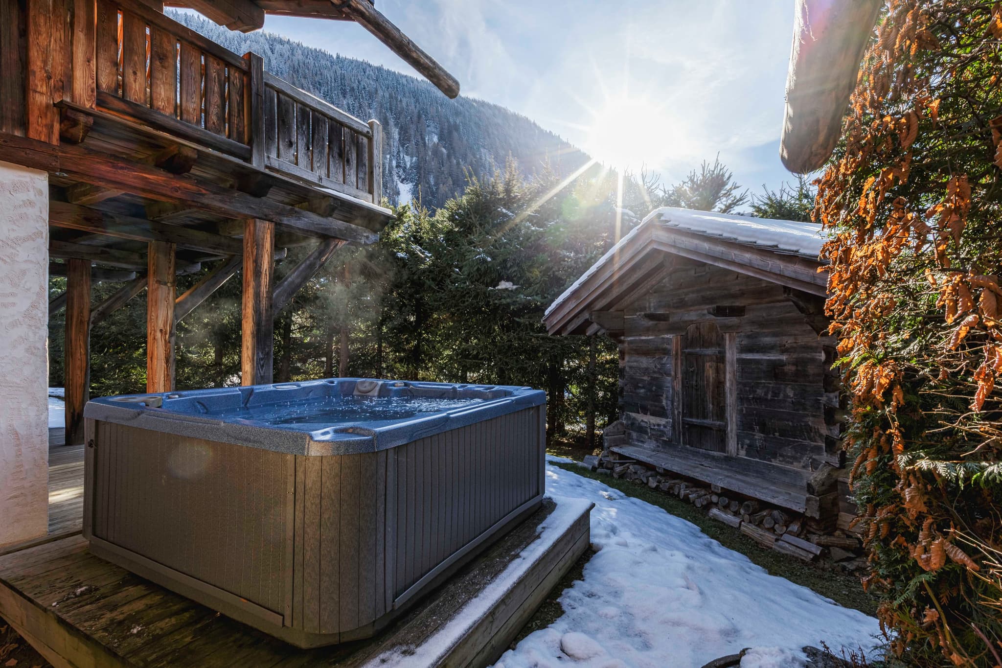 Outdoor hot tub on a snowy terrace with mountain views
