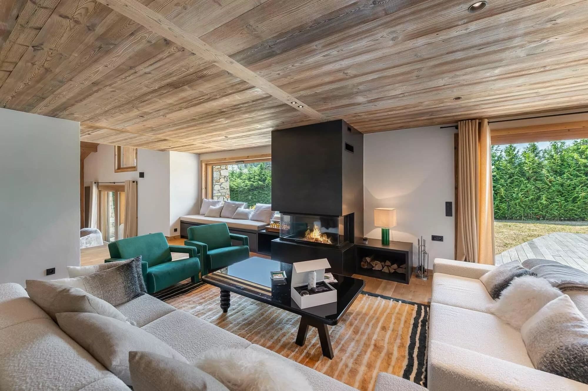 Living room with sofas arranged around a three-sided wood fireplace