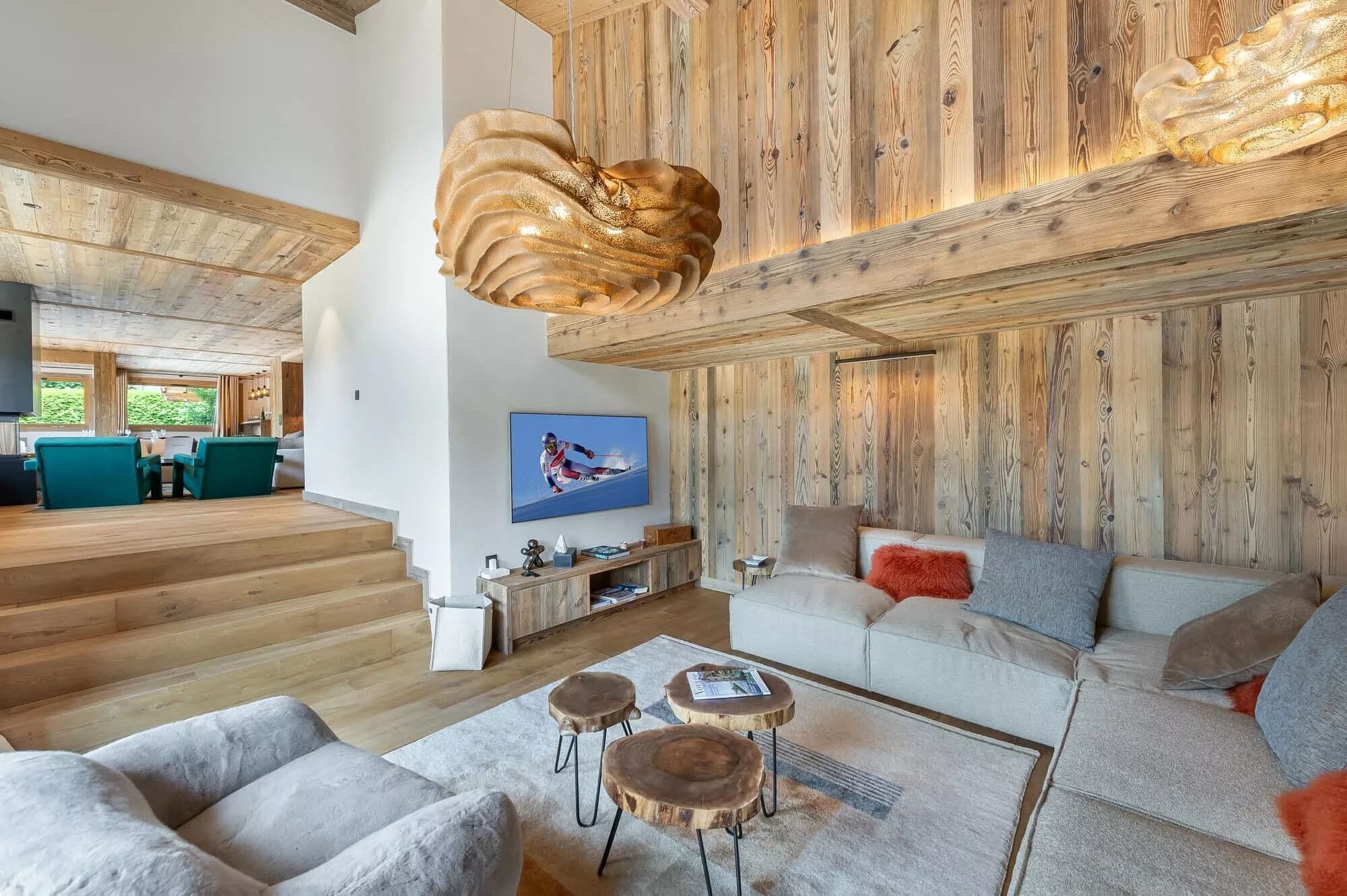 TV lounge with sectional sofa beneath double-height timber walls