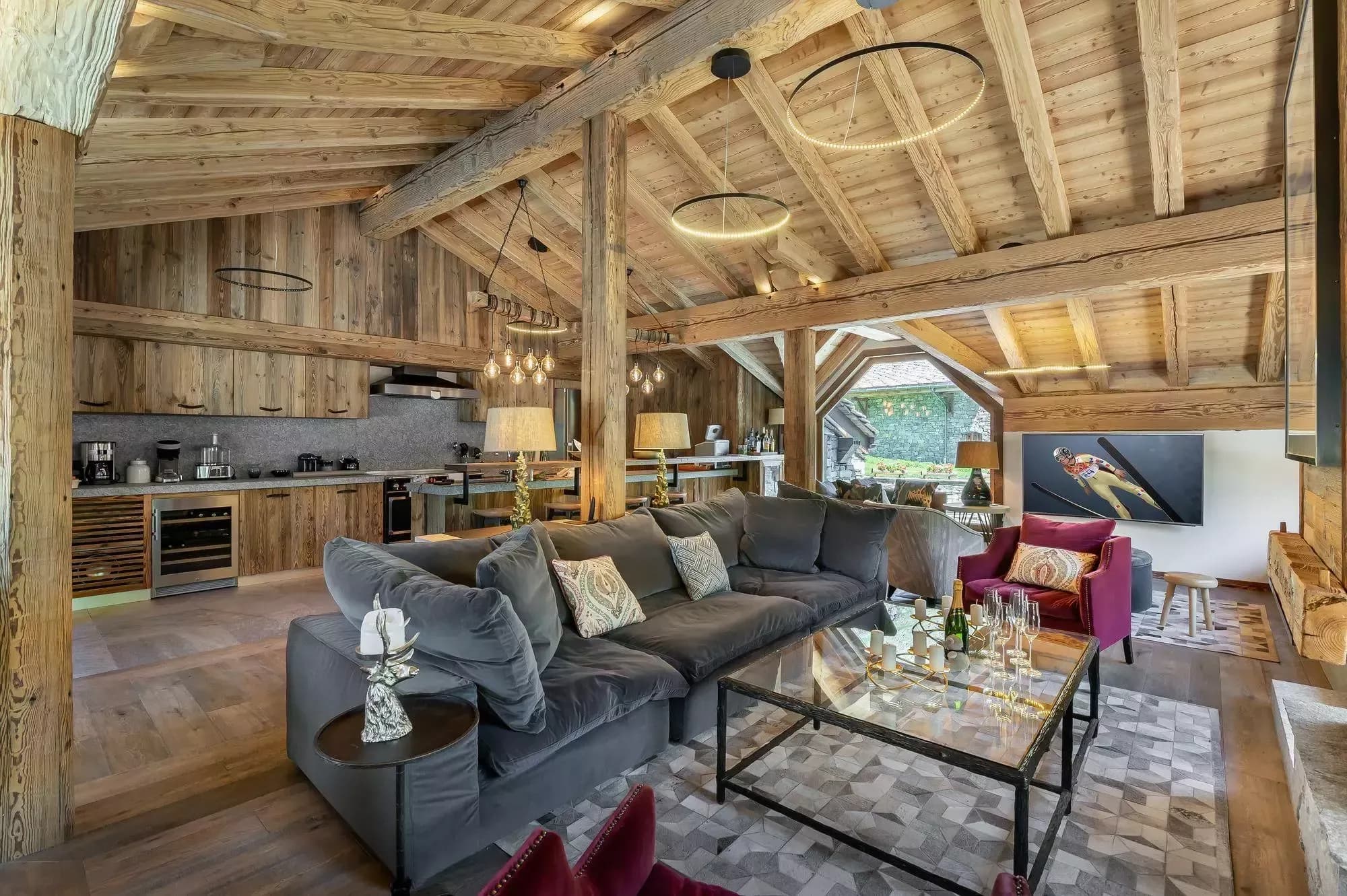 Open-plan living room and kitchen beneath exposed timber beams