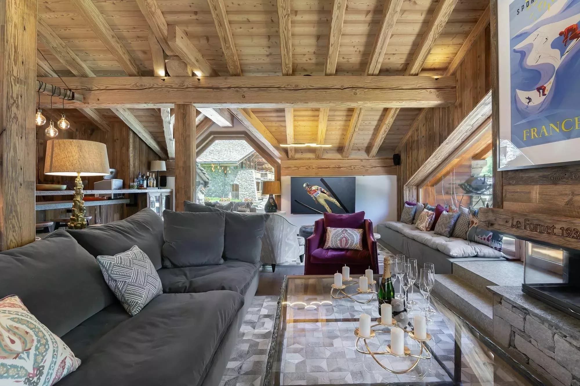 Living room with wraparound sofas, wood fireplace and balcony windows
