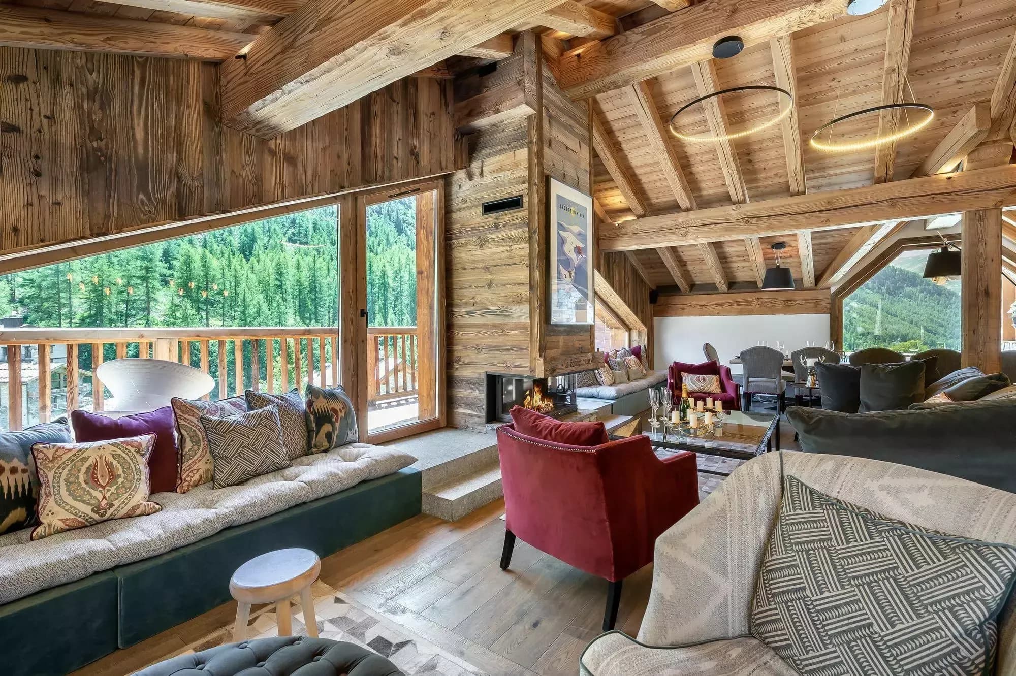 Living room with exposed beams, mountain artwork and balcony access