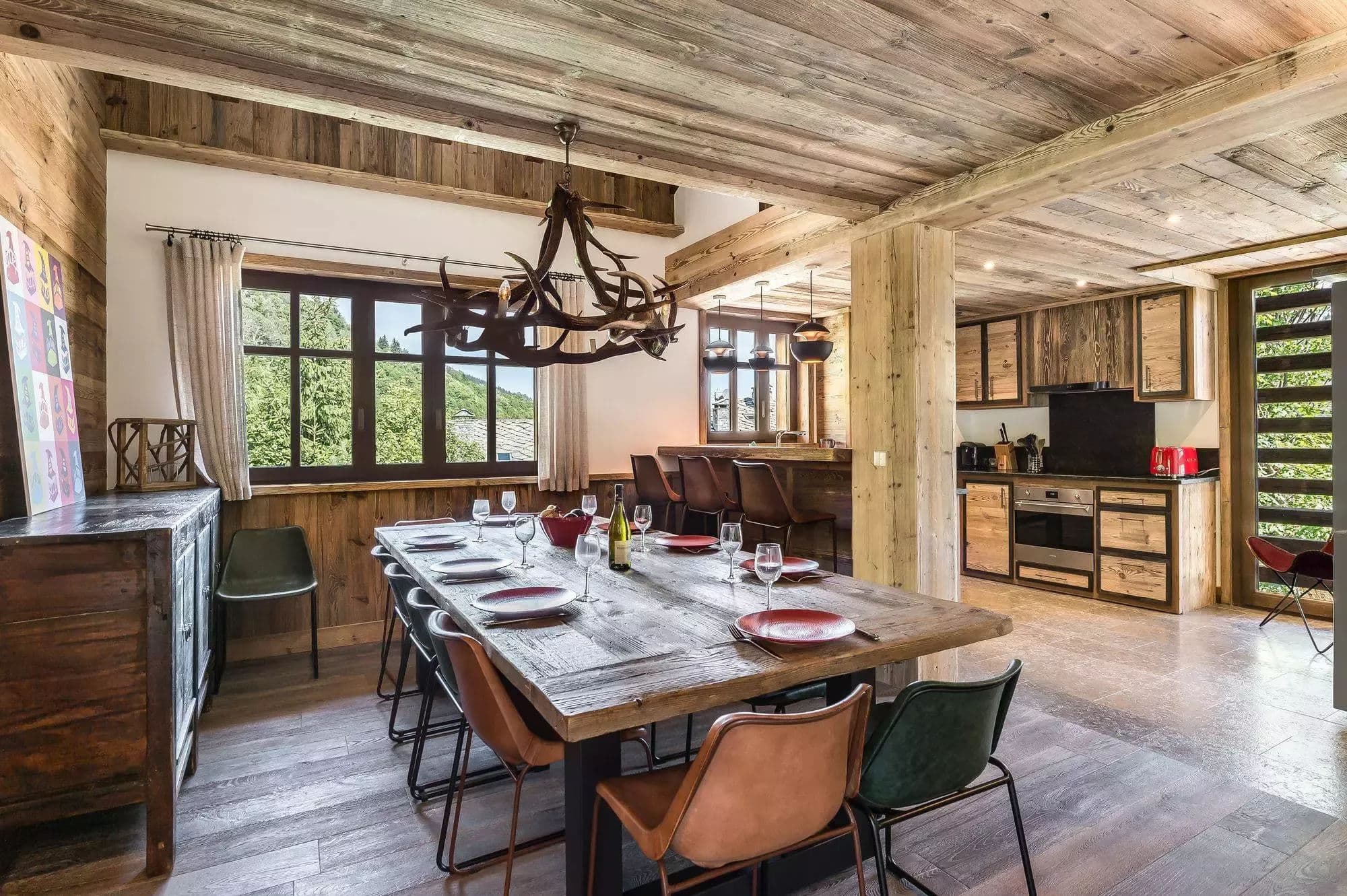 Dining area with the open kitchen and forest-facing windows