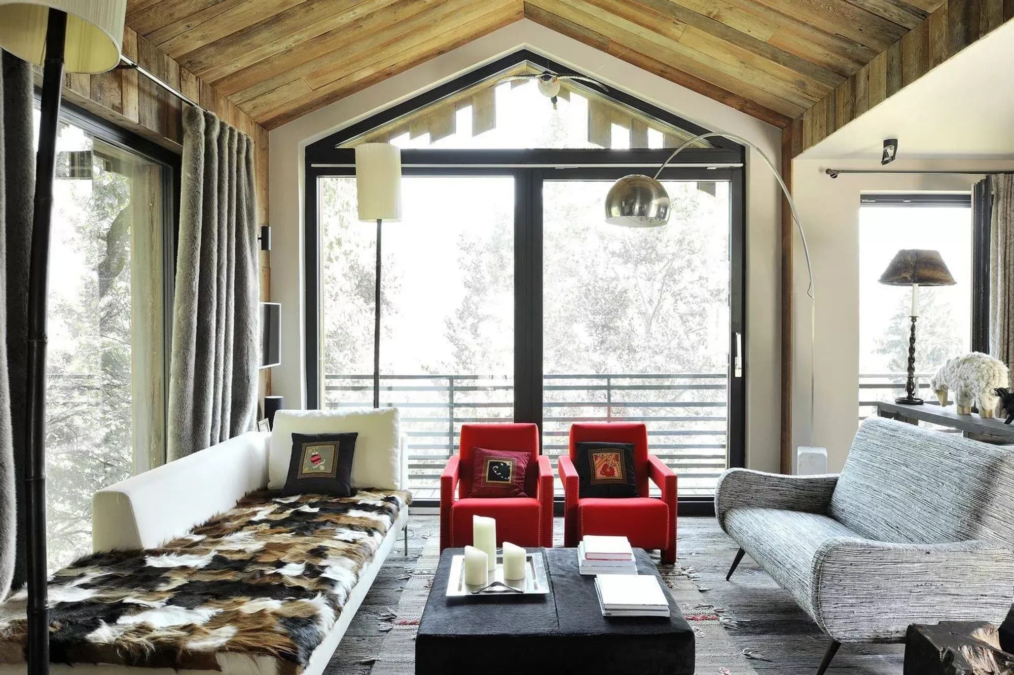 Living room with red armchairs and windows overlooking the mountains