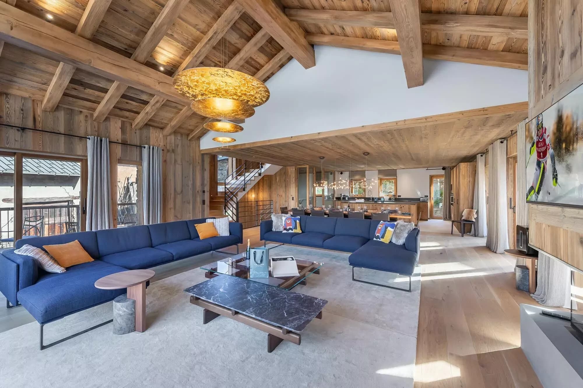 Open-plan living room, dining area and kitchen beneath timber beams