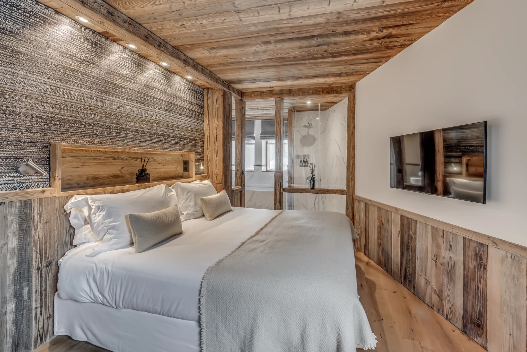 Double bedroom with timber panelling and stone accents