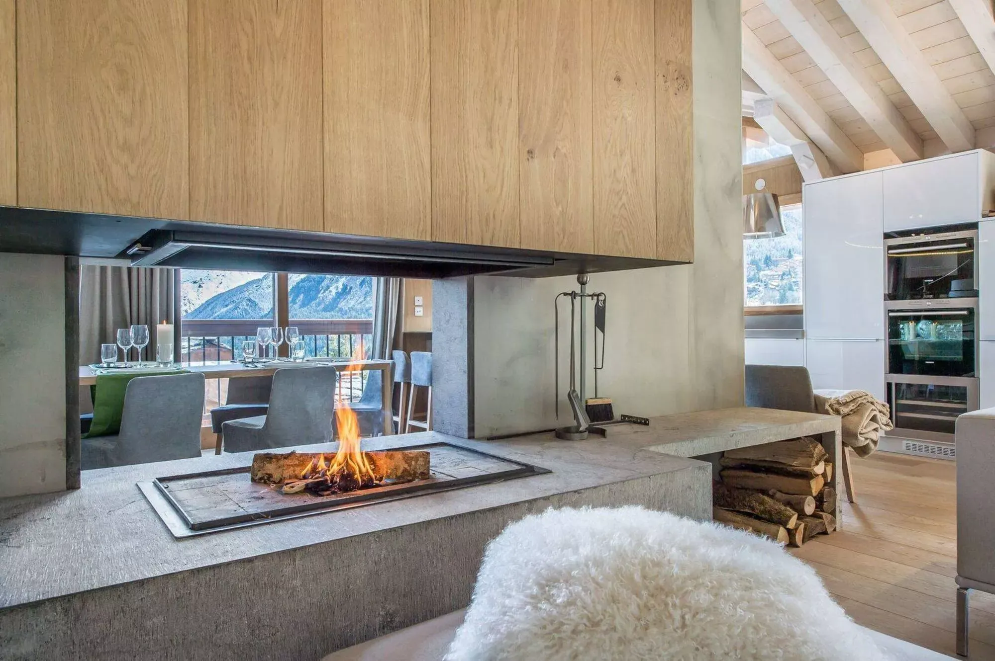 Central fireplace and open-plan living space beneath exposed roof beams