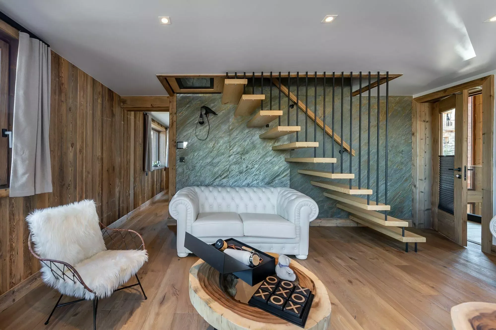 Lounge seating beside the staircase and stone feature wall