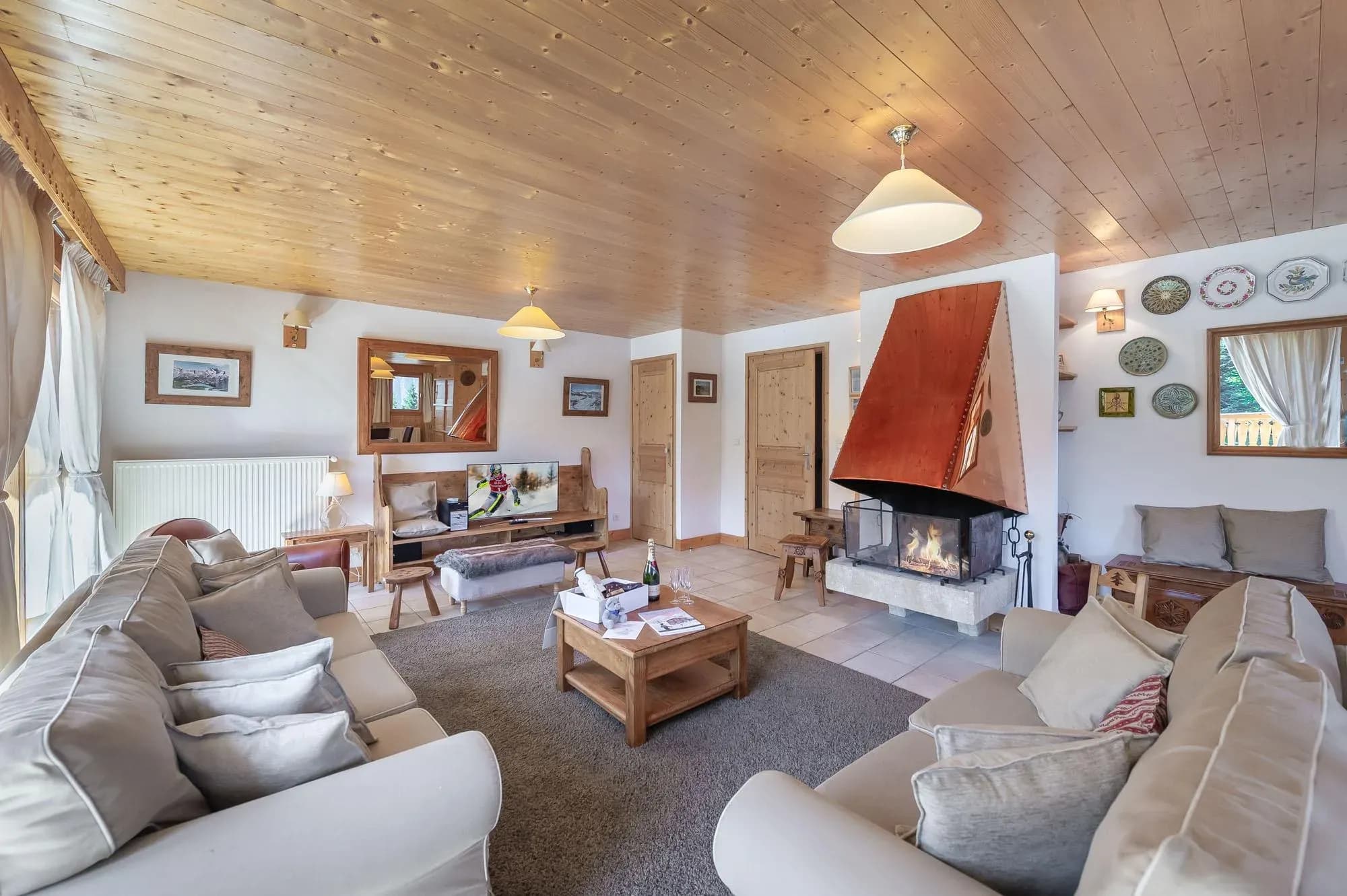 Living area with copper hood fireplace, flat-screen TV, and dual sofa seating
