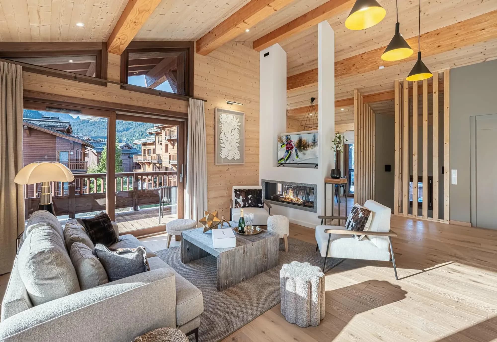 Living room with grey sofa, armchairs and gas fireplace beside a balcony door