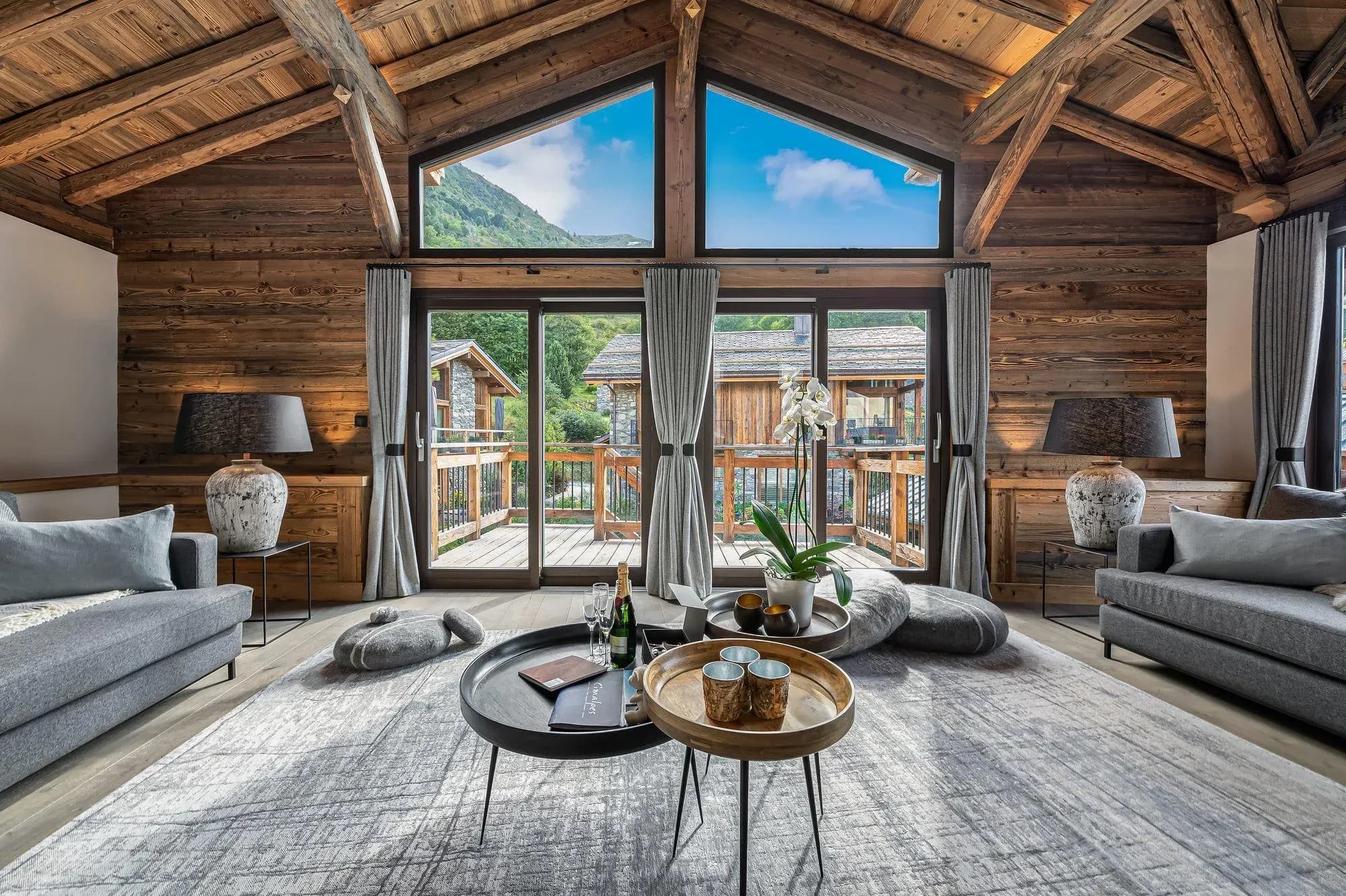 Living room with gable windows, two grey sofas and balcony doors