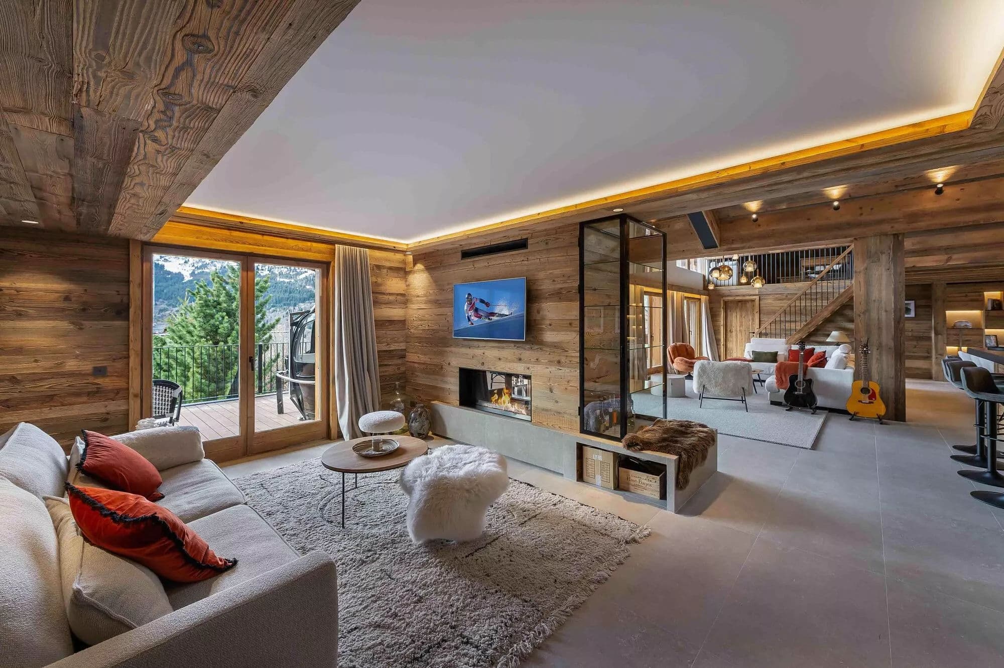 TV lounge with a fireplace and doors opening to the terrace