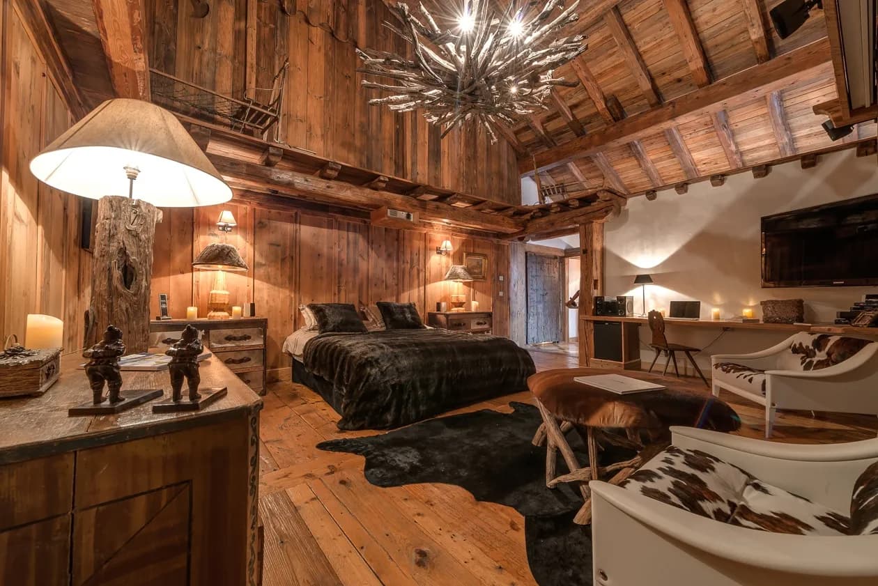 Primary bedroom with timber finishes, seating and chandelier
