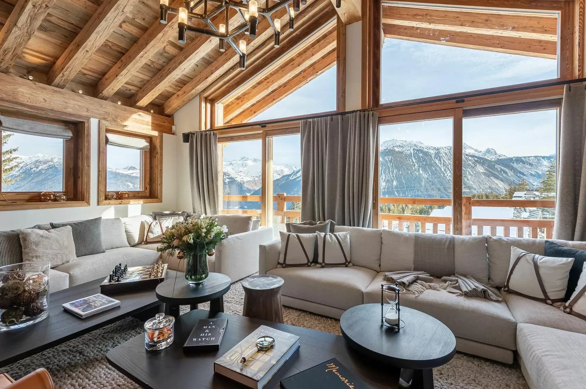 Sunlit living room with sectional seating, exposed timber beams and mountain views