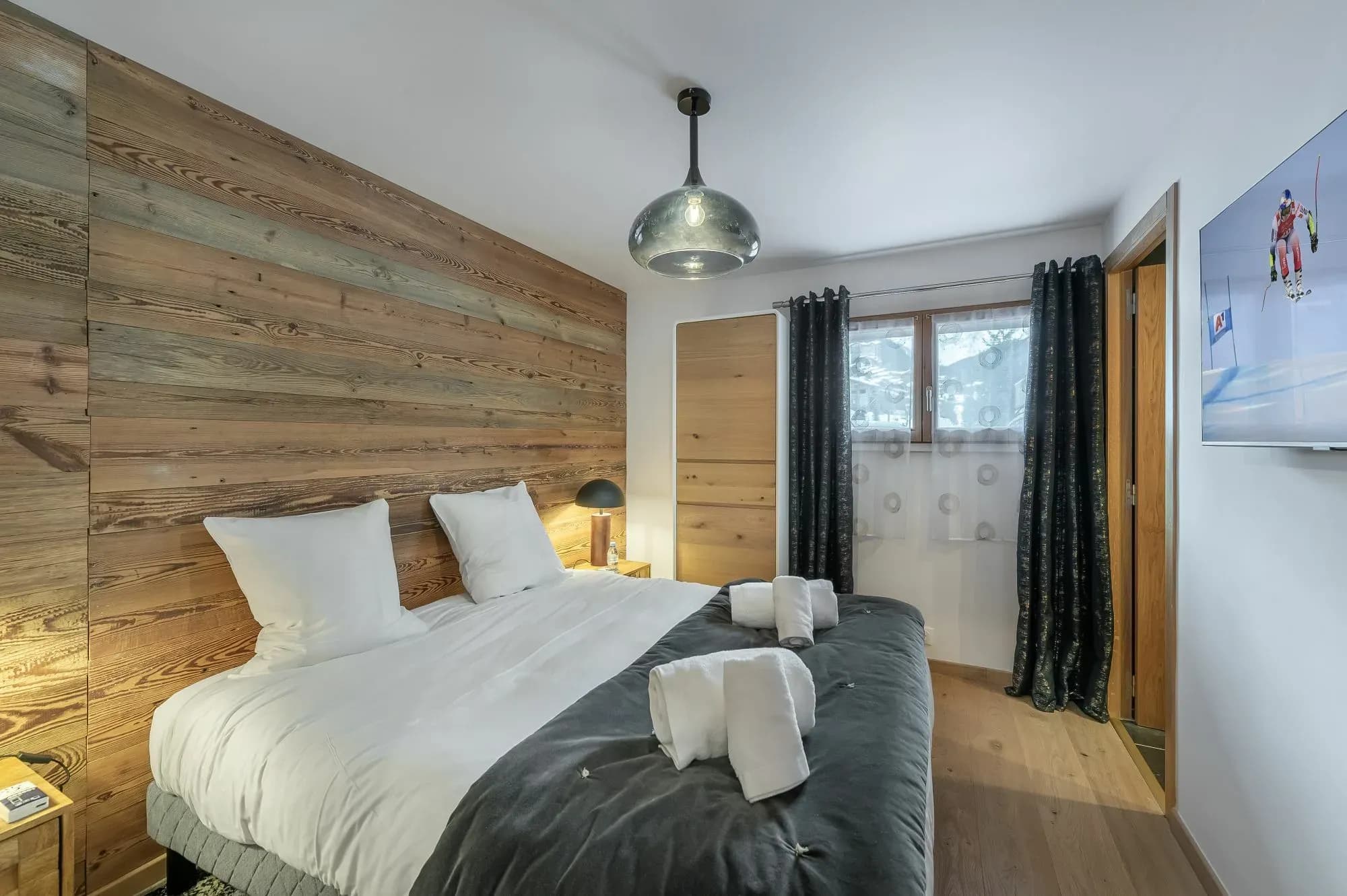 Bedroom 2 – double bed, reclaimed wood wall, wall-mounted TV and en-suite door