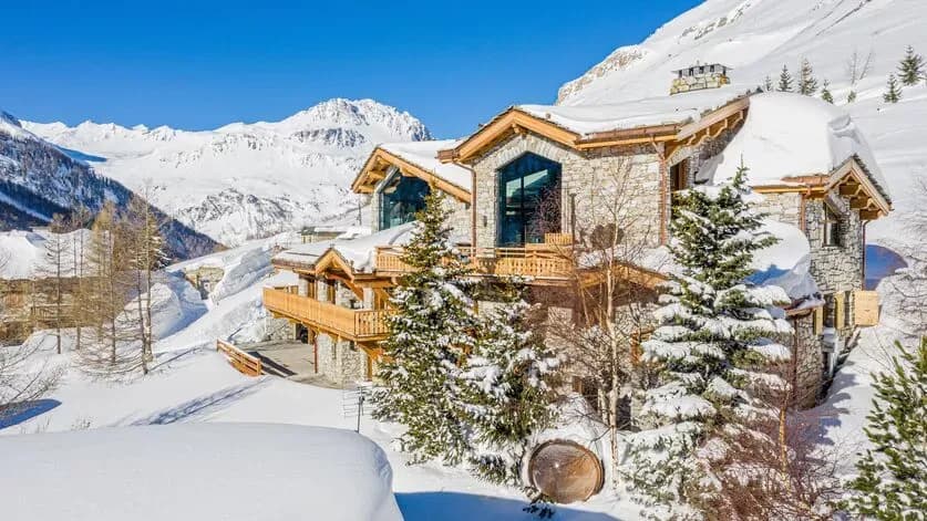 Stone chalet exterior surrounded by snow-covered mountain slopes