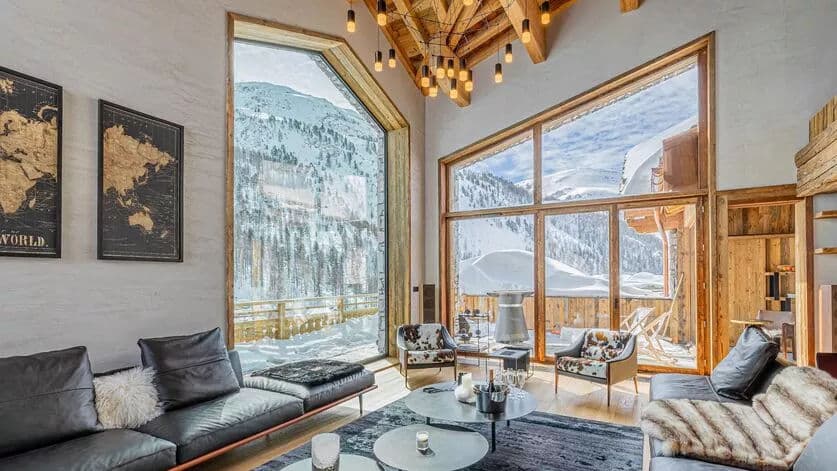 Double-height living room with floor-to-ceiling mountain views