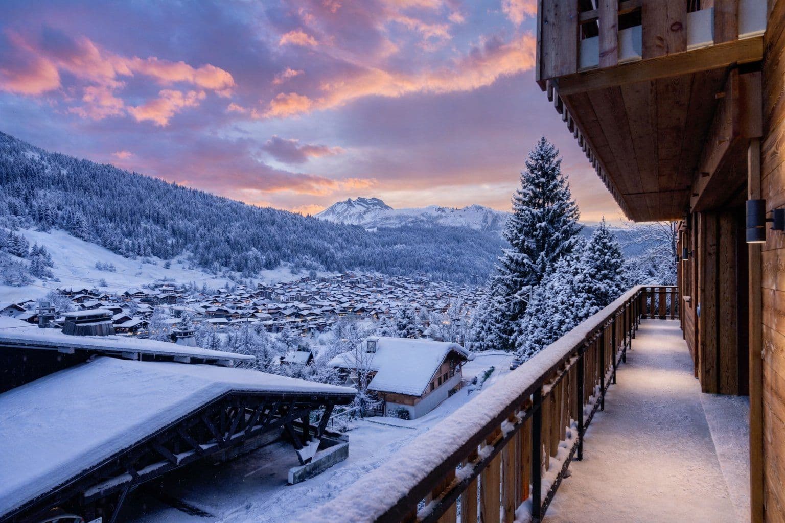 Snow-covered balcony with south-facing mountain and valley views at sunset