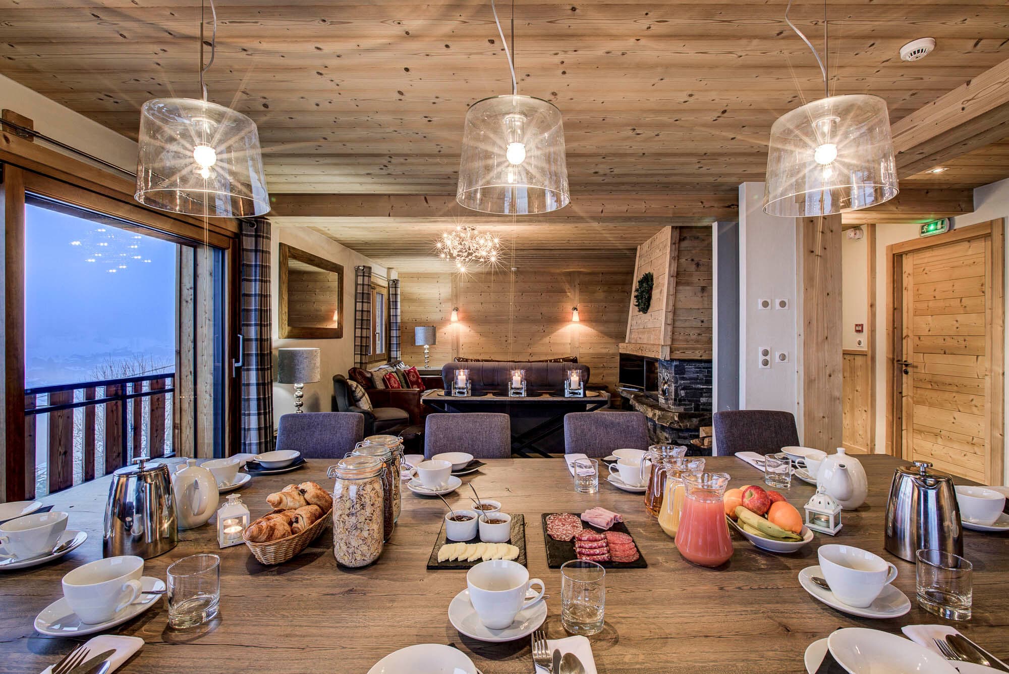 Dining area with a large oak table beside the open fireplace
