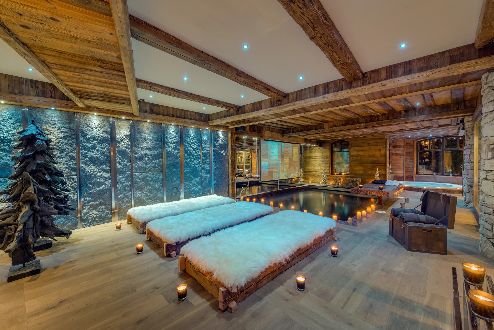 Indoor swimming pool with loungers beside floor-to-ceiling windows