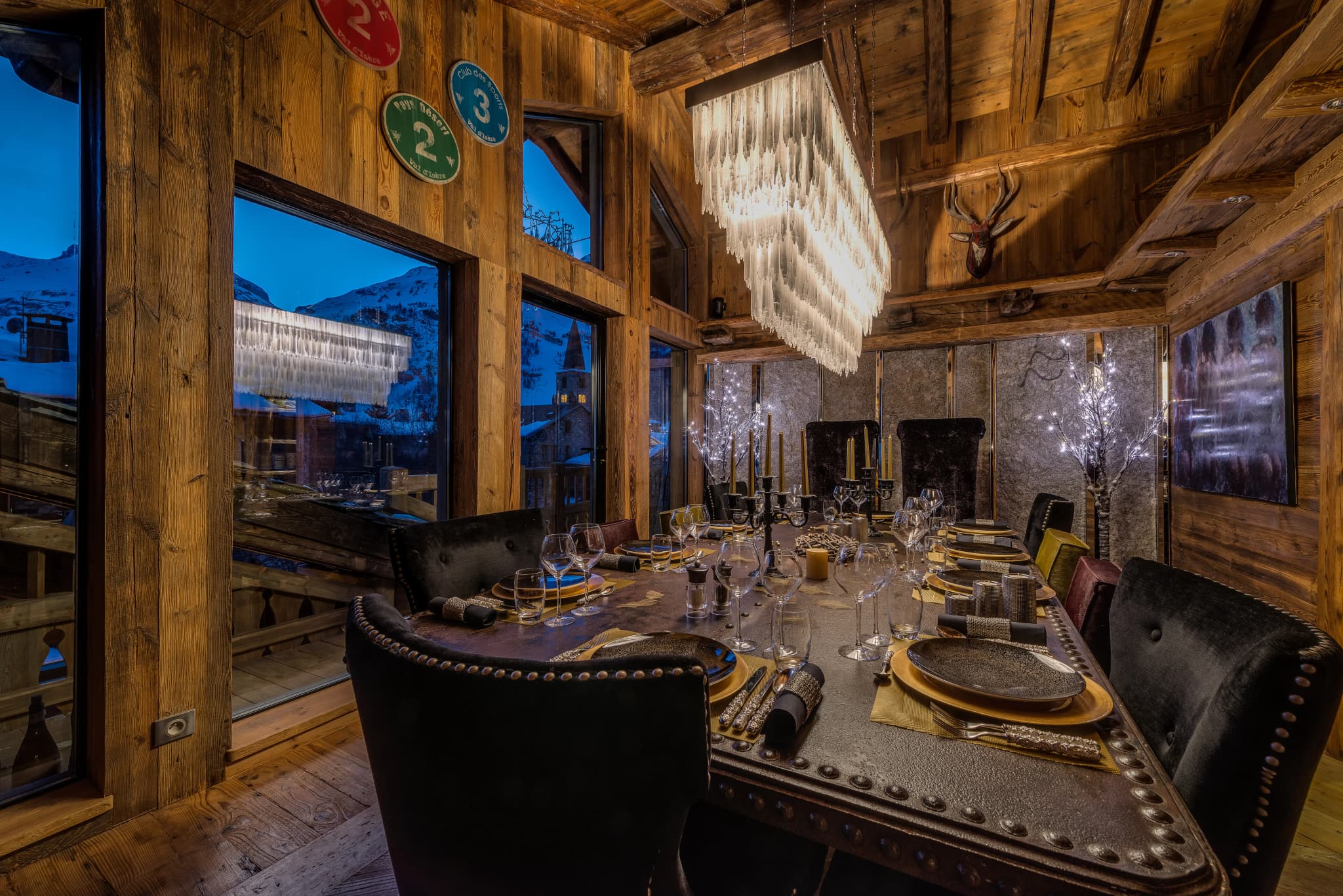 Dining table beside tall windows and crystal lighting