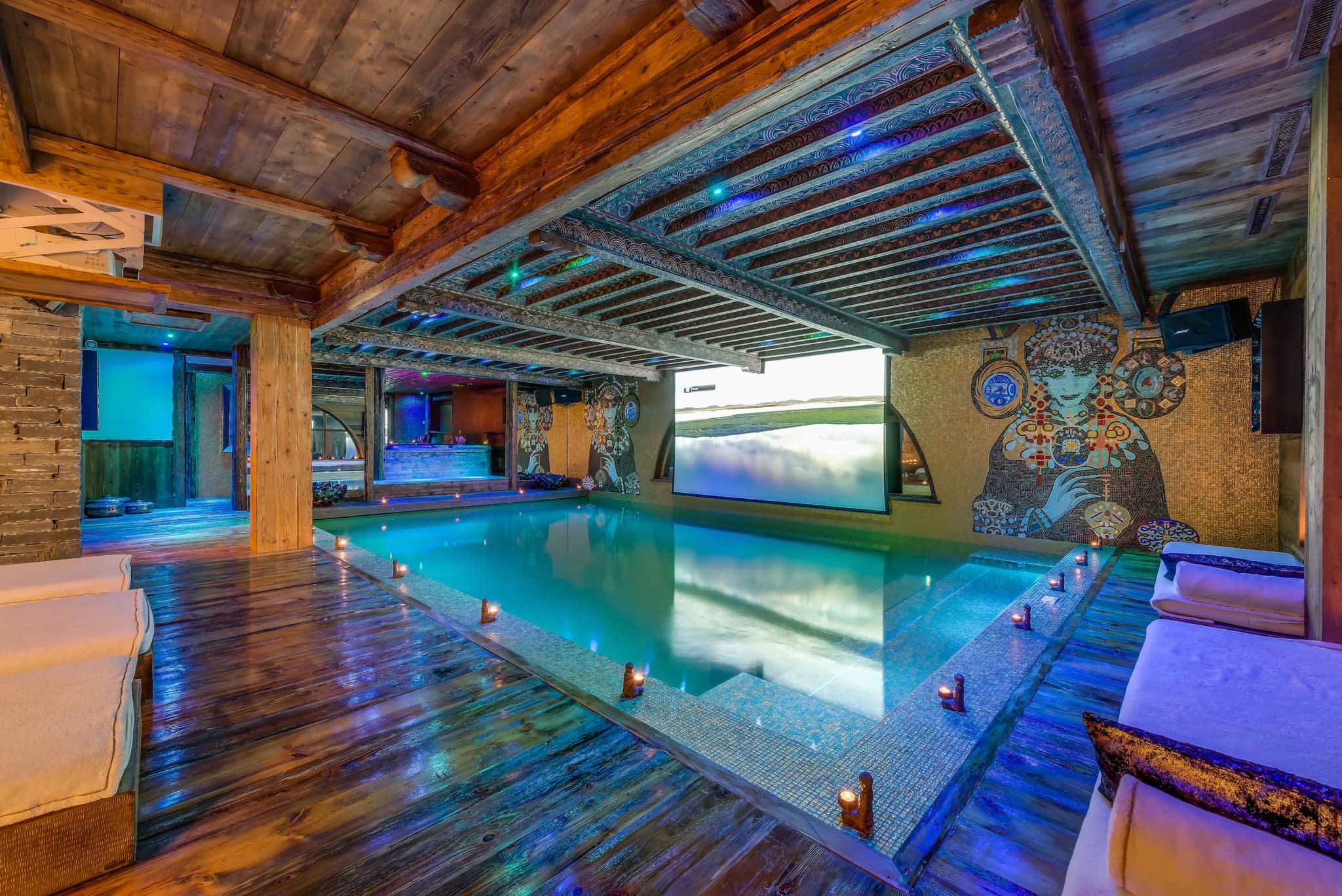Indoor pool with mosaic walls, painted ceiling and projector screen