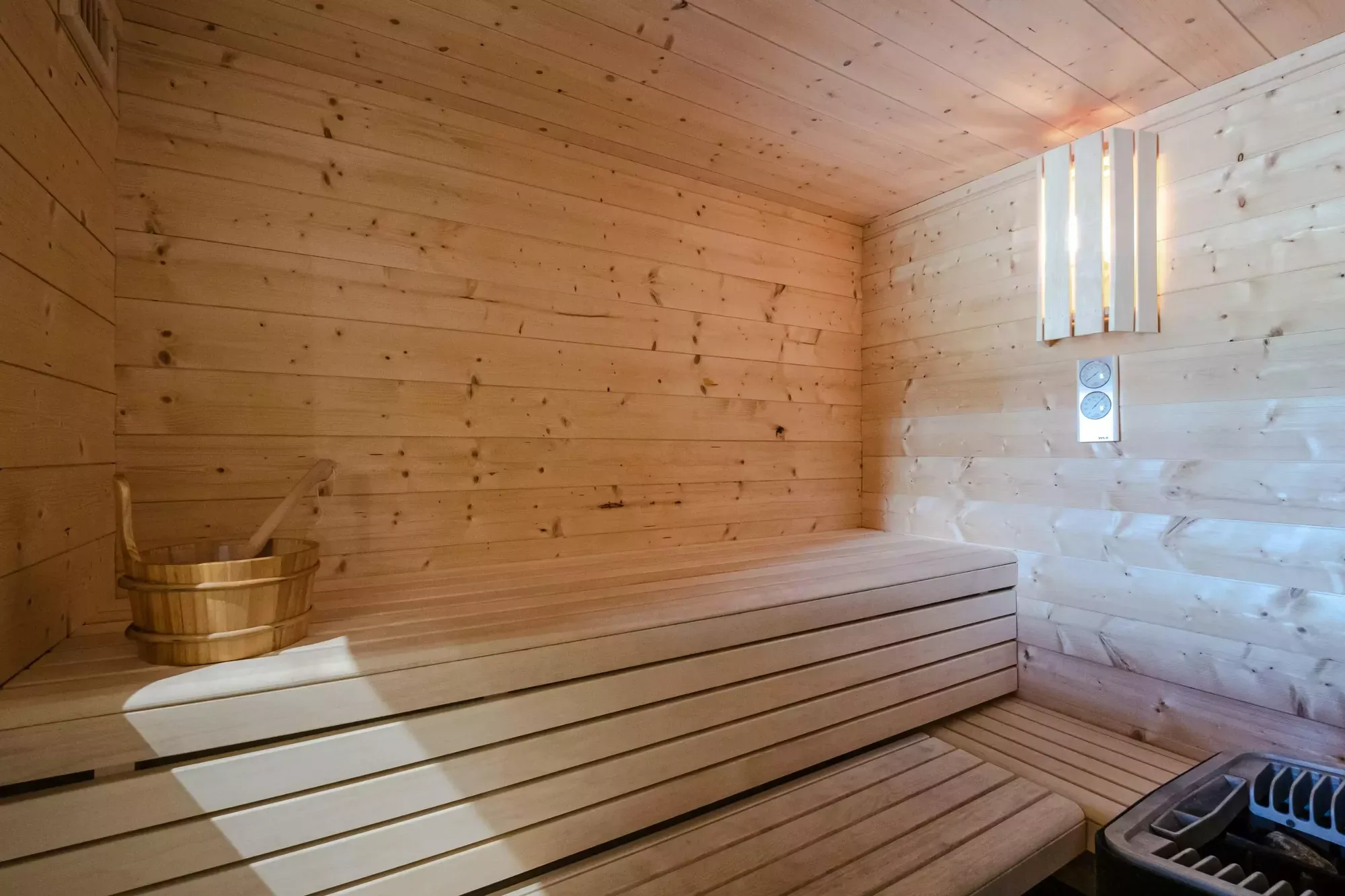 Timber-lined private sauna with tiered bench seating