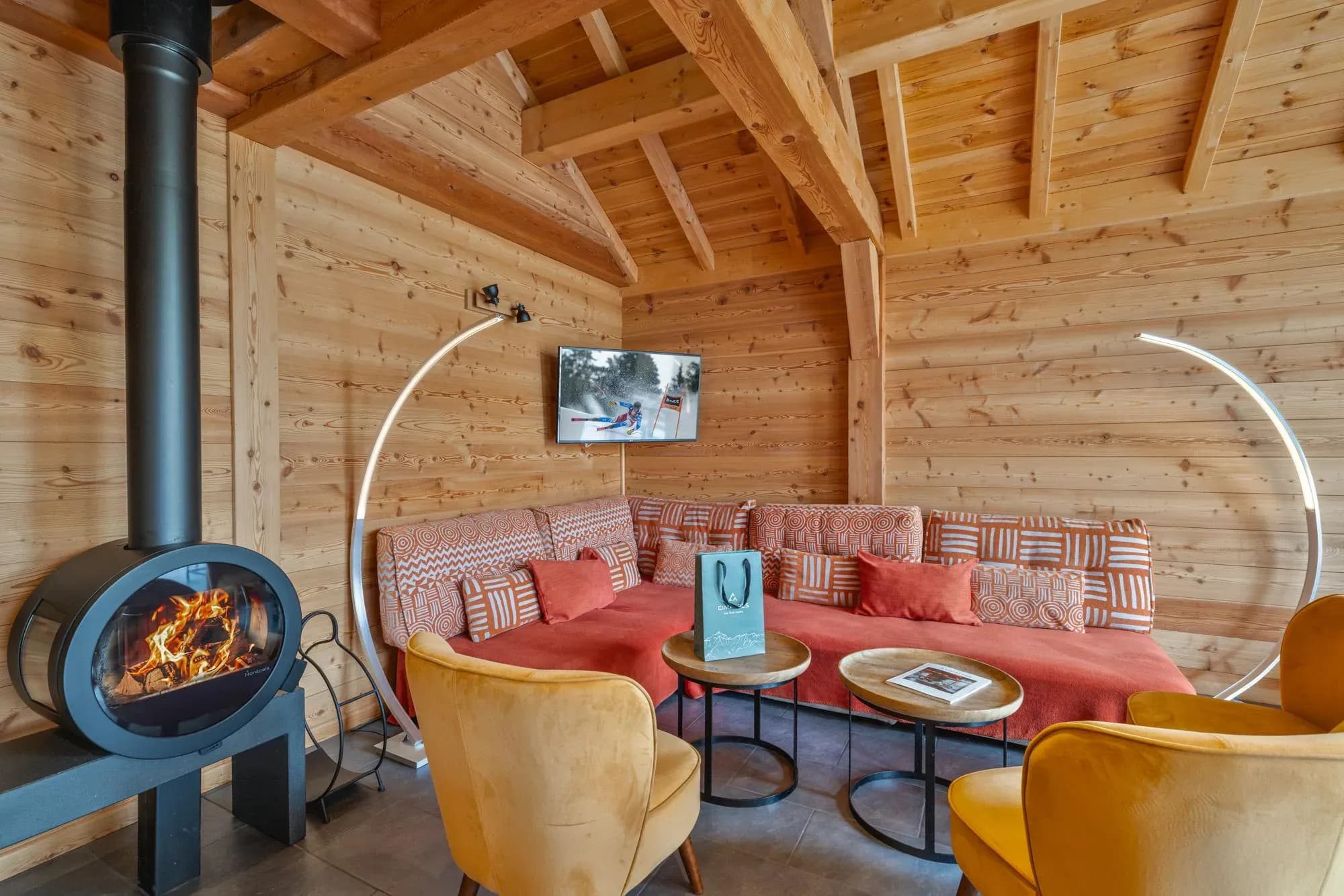 Living room with wood stove, corner sofa, two coffee tables and velvet armchairs