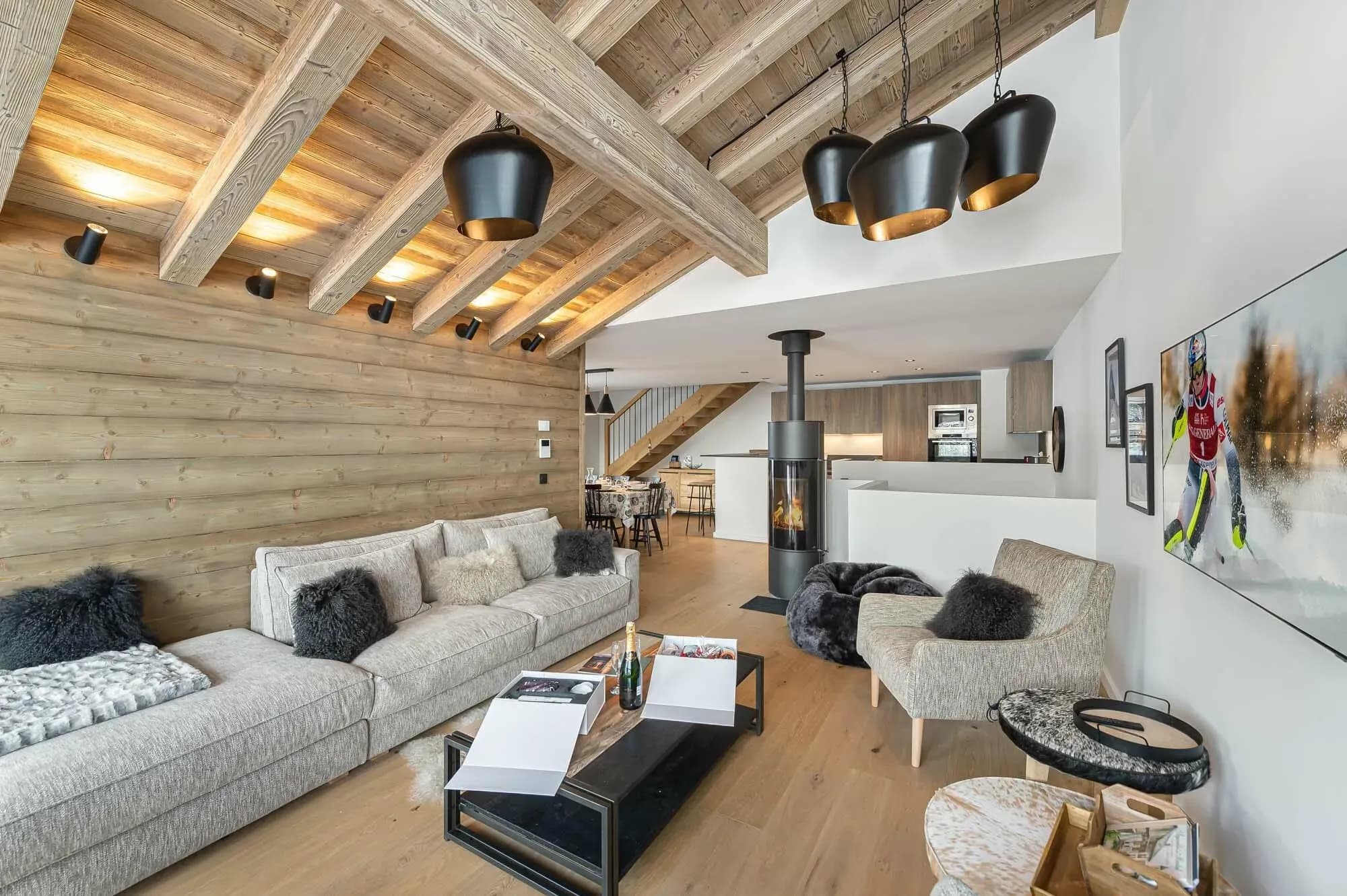 Living room with corner sofa, wood stove and exposed beams