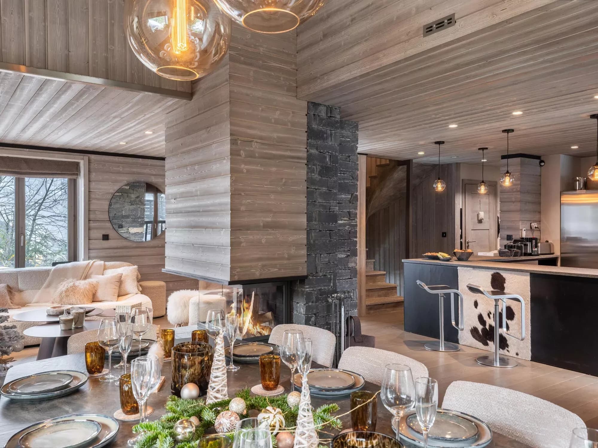 Set dining table beside the central fireplace and open kitchen