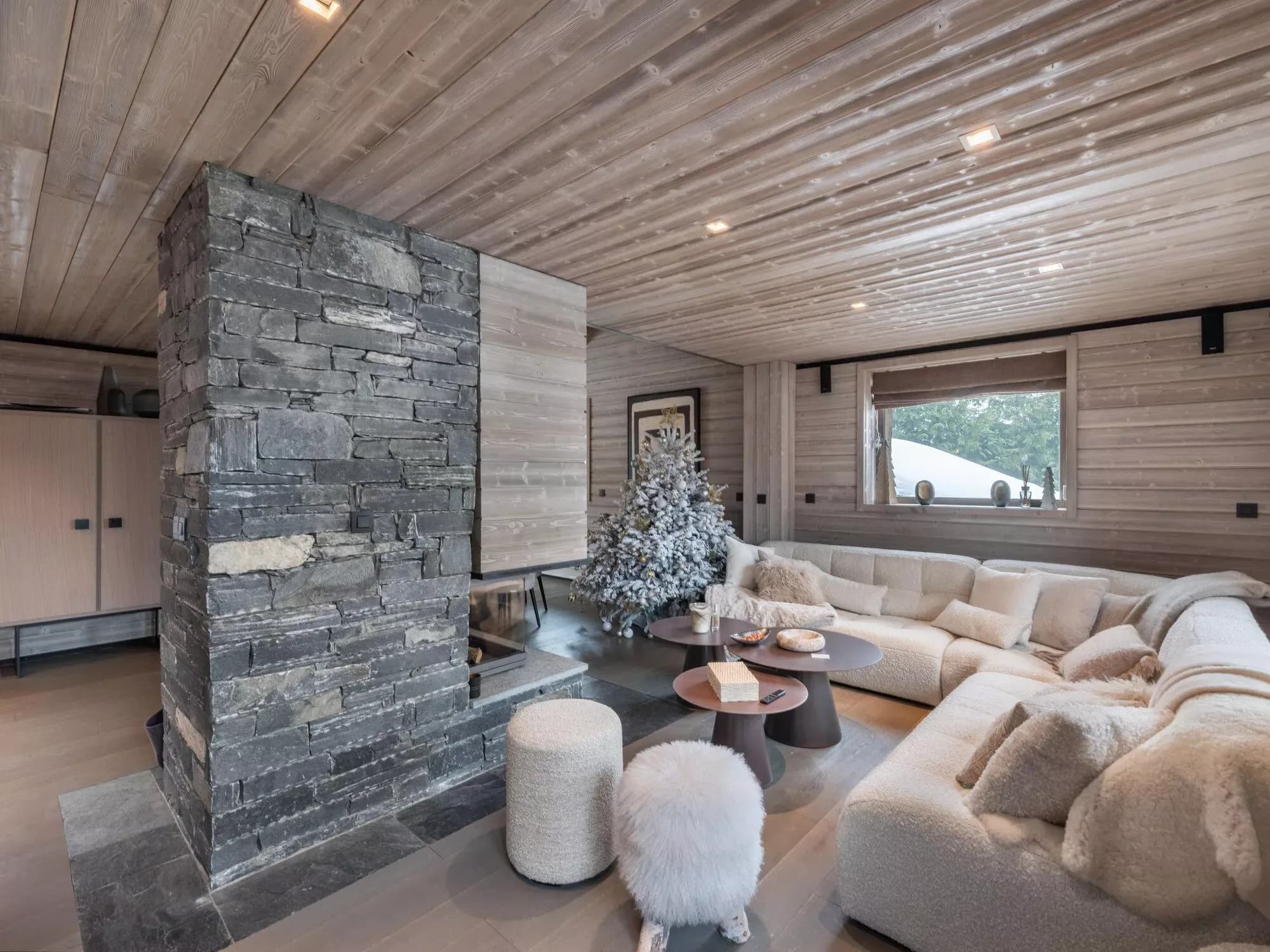 Living room with sectional sofa and three-sided stone fireplace
