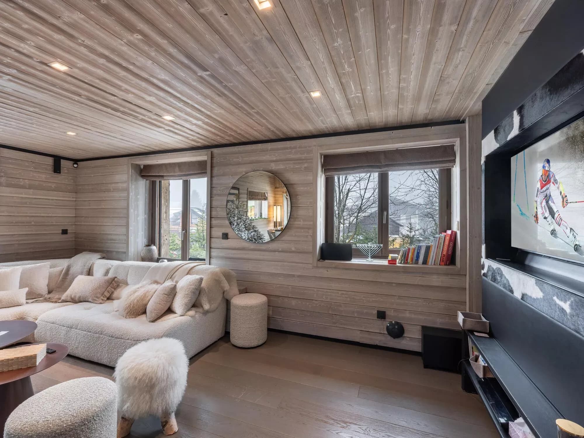 Lounge seating area facing a wall-mounted television and windows