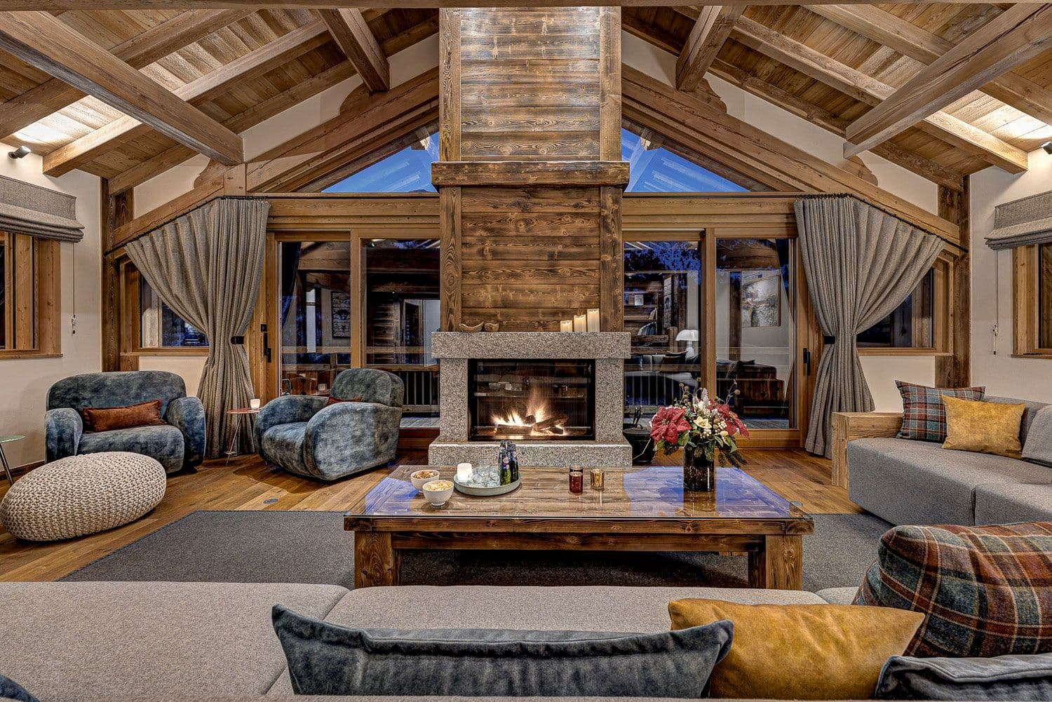 Living room with double-sided fireplace, vaulted wood ceilings, seating for 10+