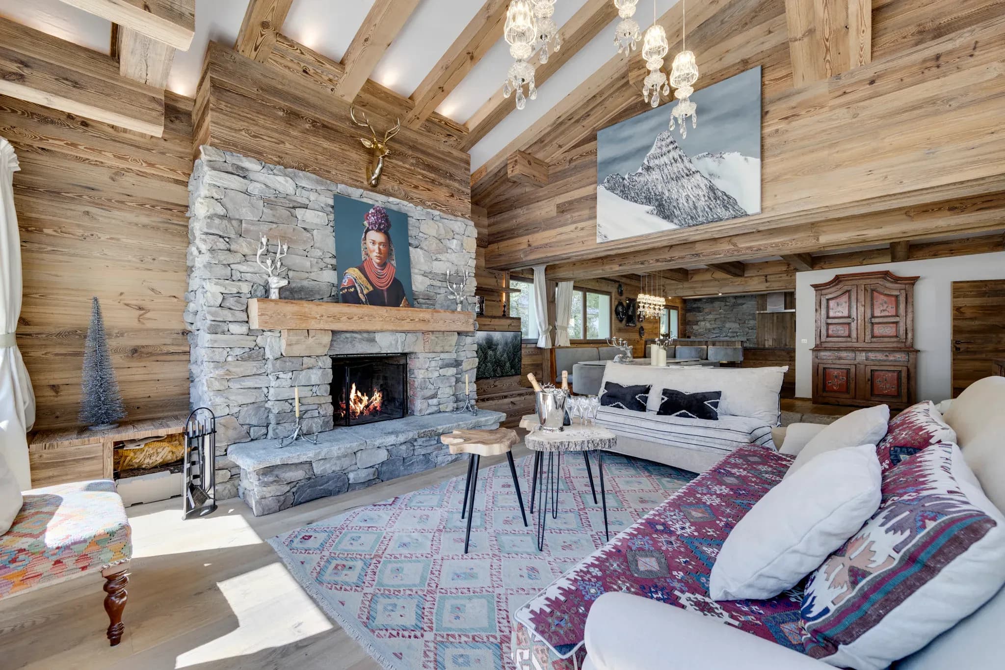 Living room with stone fireplace, sofas and vaulted timber ceiling