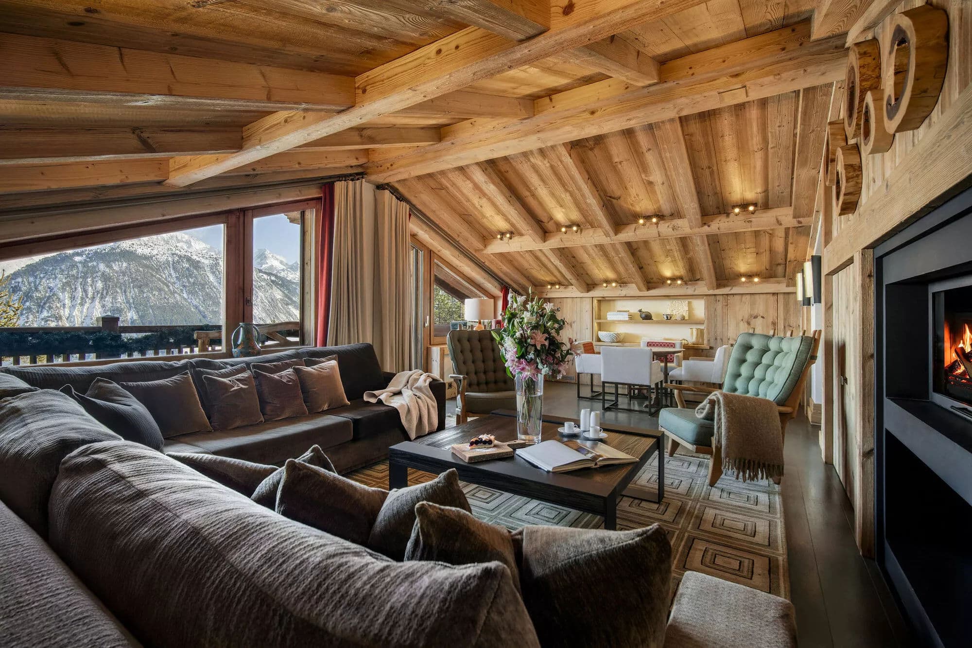 Living and dining area with timber ceilings and mountain views