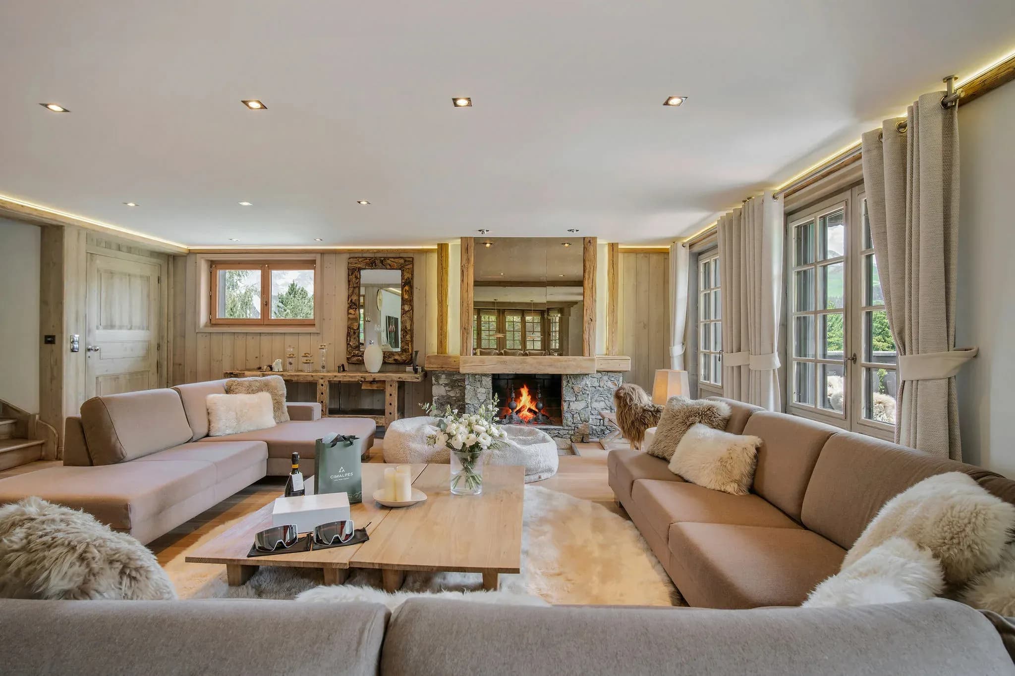 Living room with dual sofas, wood-burning fireplace, and French doors to terrace