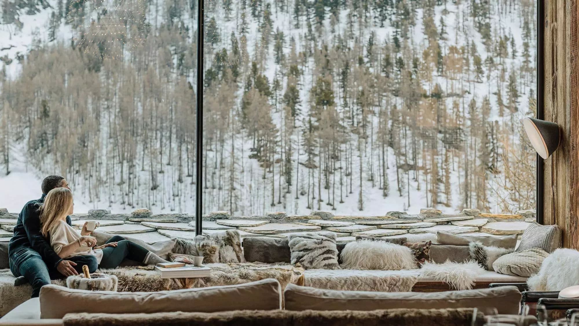 Window seating overlooking the snow-covered forest above Le Fornet