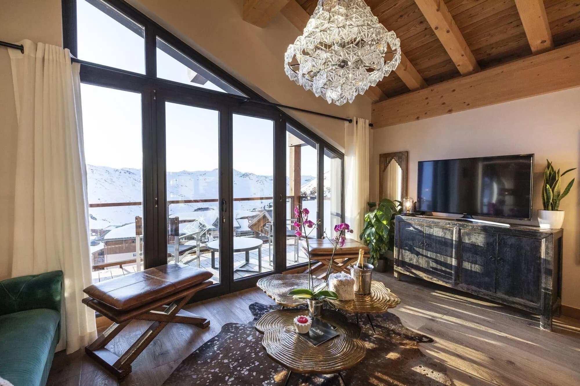 Living room with television, lounge seating and mountain-facing windows