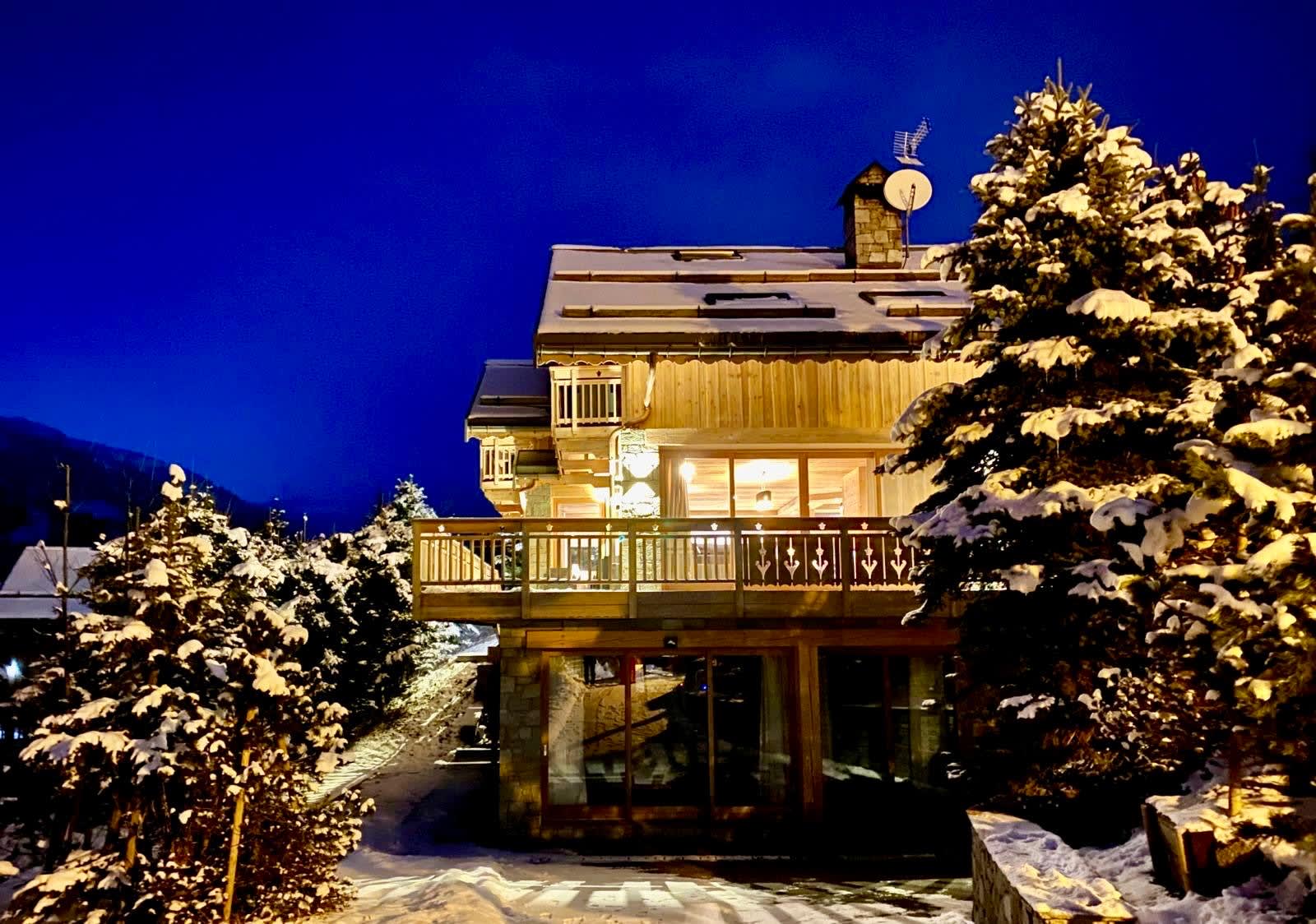 Snowy exterior of Chalet Phoebe lit at dusk