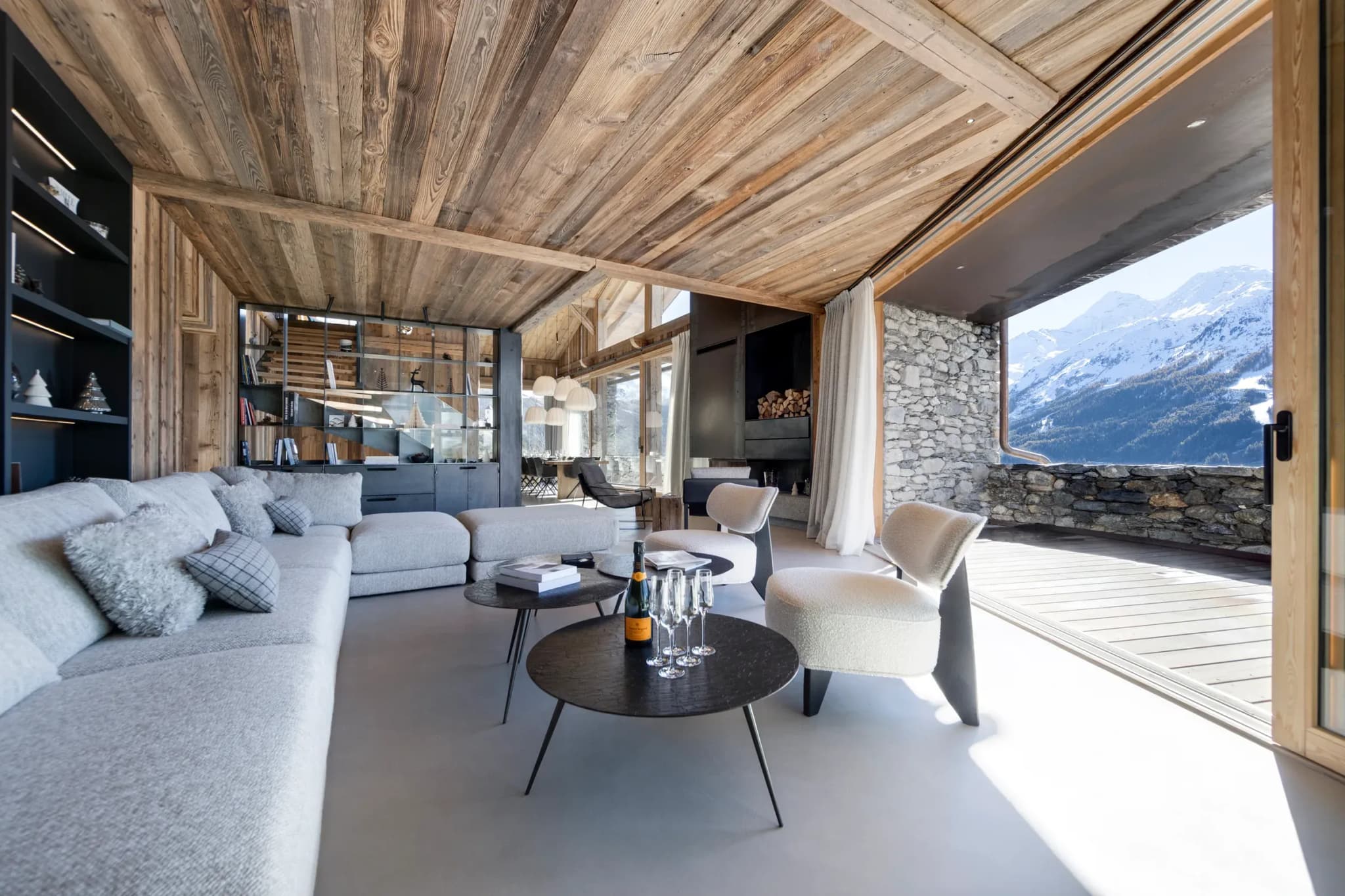 Living room with corner sofa, armchairs and open doors to the terrace