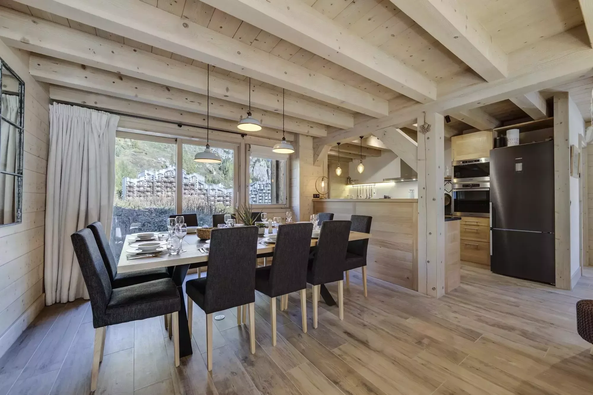 Dining table beside the open kitchen with mountain views beyond