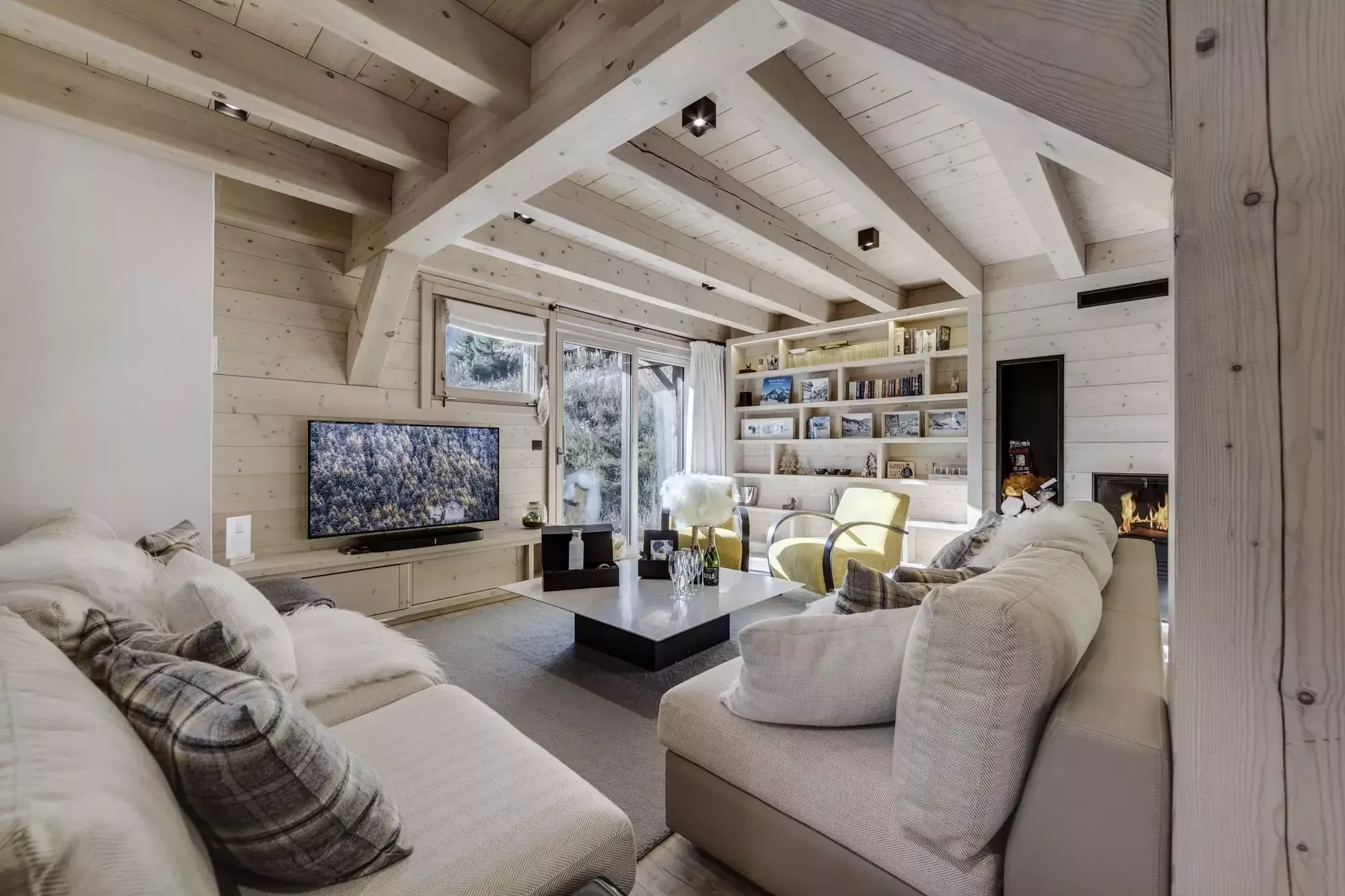 Living room with sectional seating, a built-in library and a fireplace