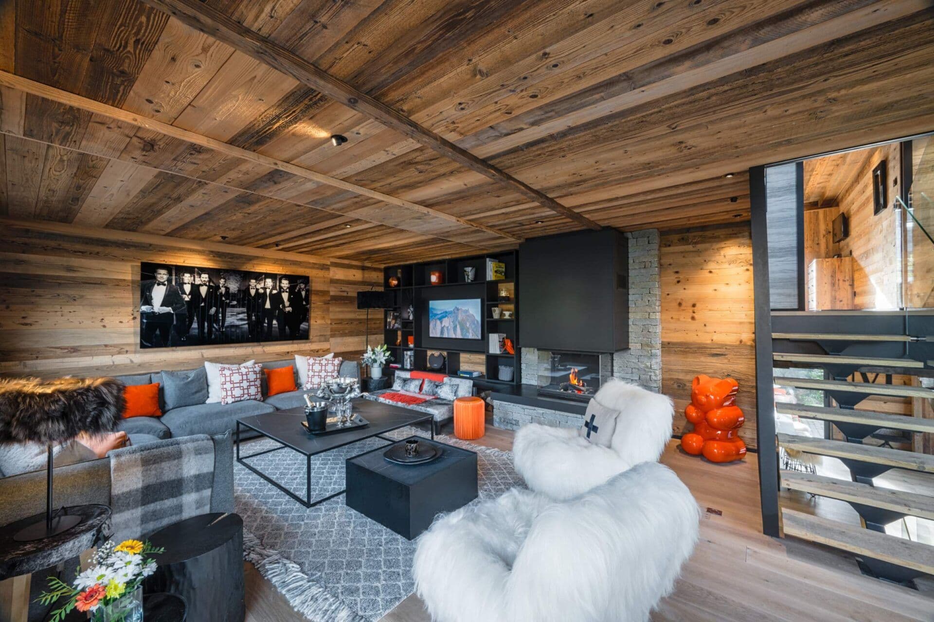 Larch-lined living room with sectional sofa, TV nook and log-burning fireplace